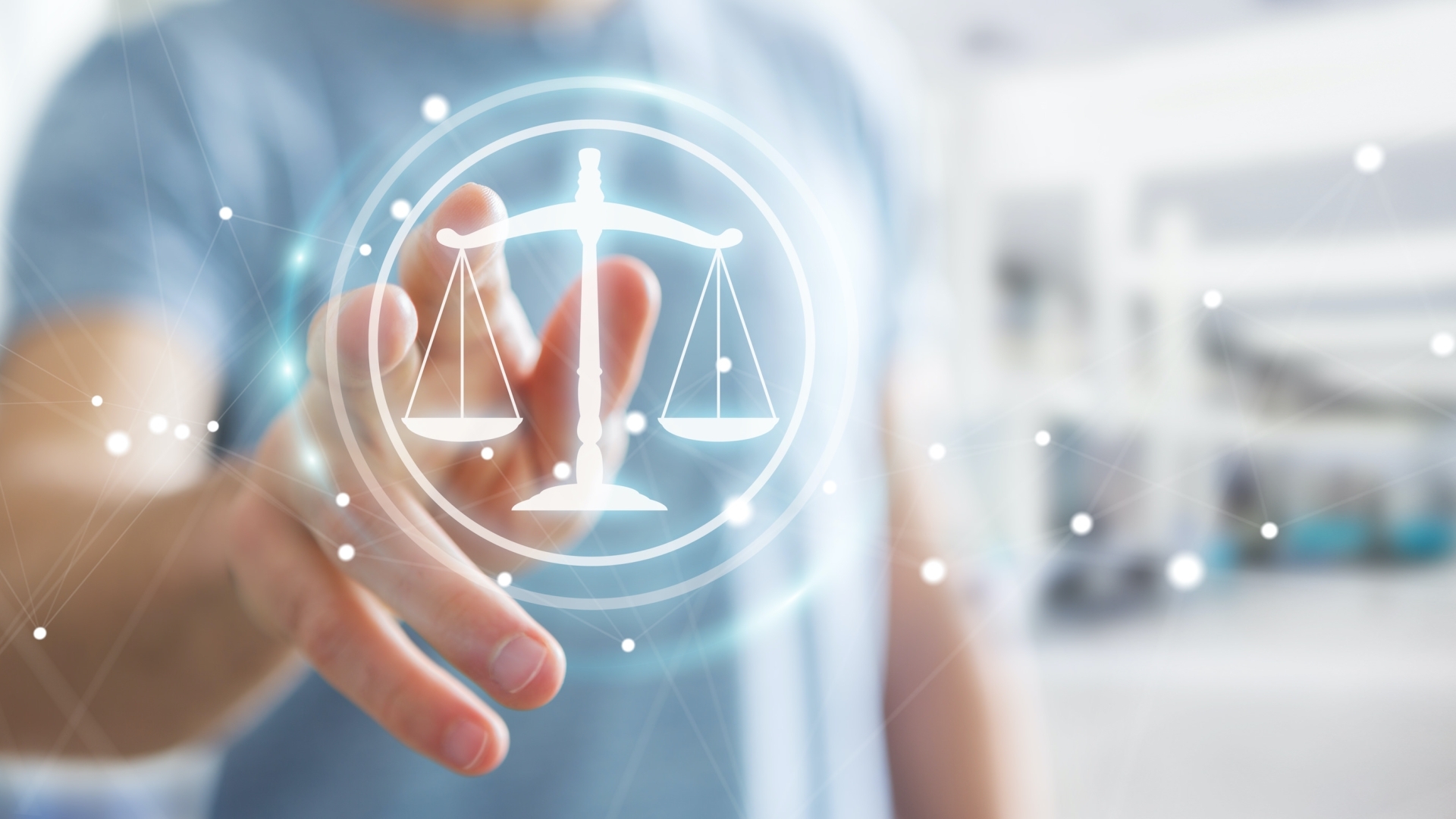 Glowing graphic of scales to represent justice overlayed on person reaching hand out to it.