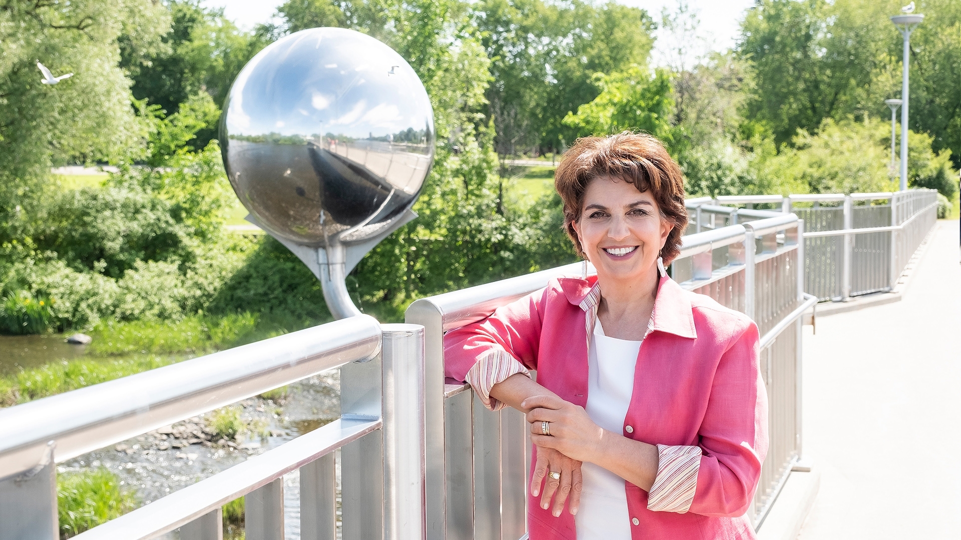La commissaire à l'information et à la protection de la vie privée, Patricia Kosseim, pose pour une photo sur un pont, avec des arbres en arrière-plan.