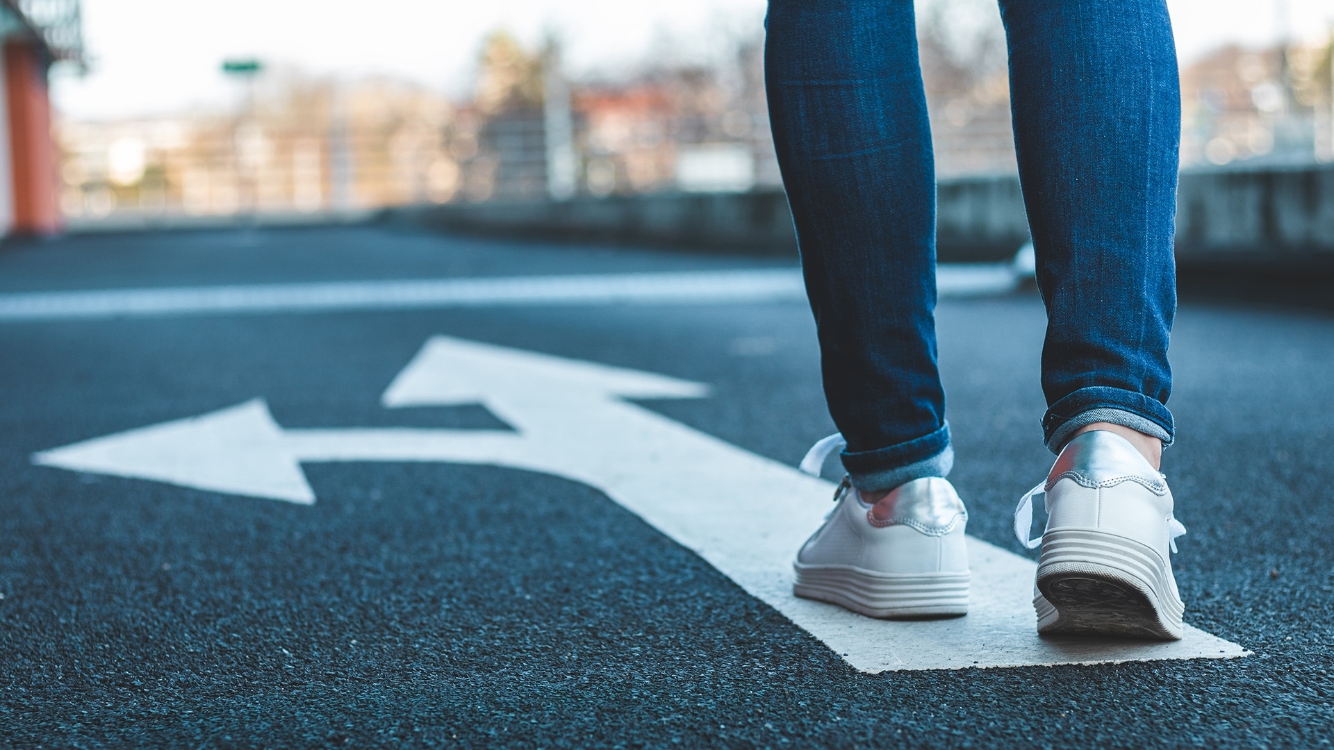 A person walking toward a fork in the road.
