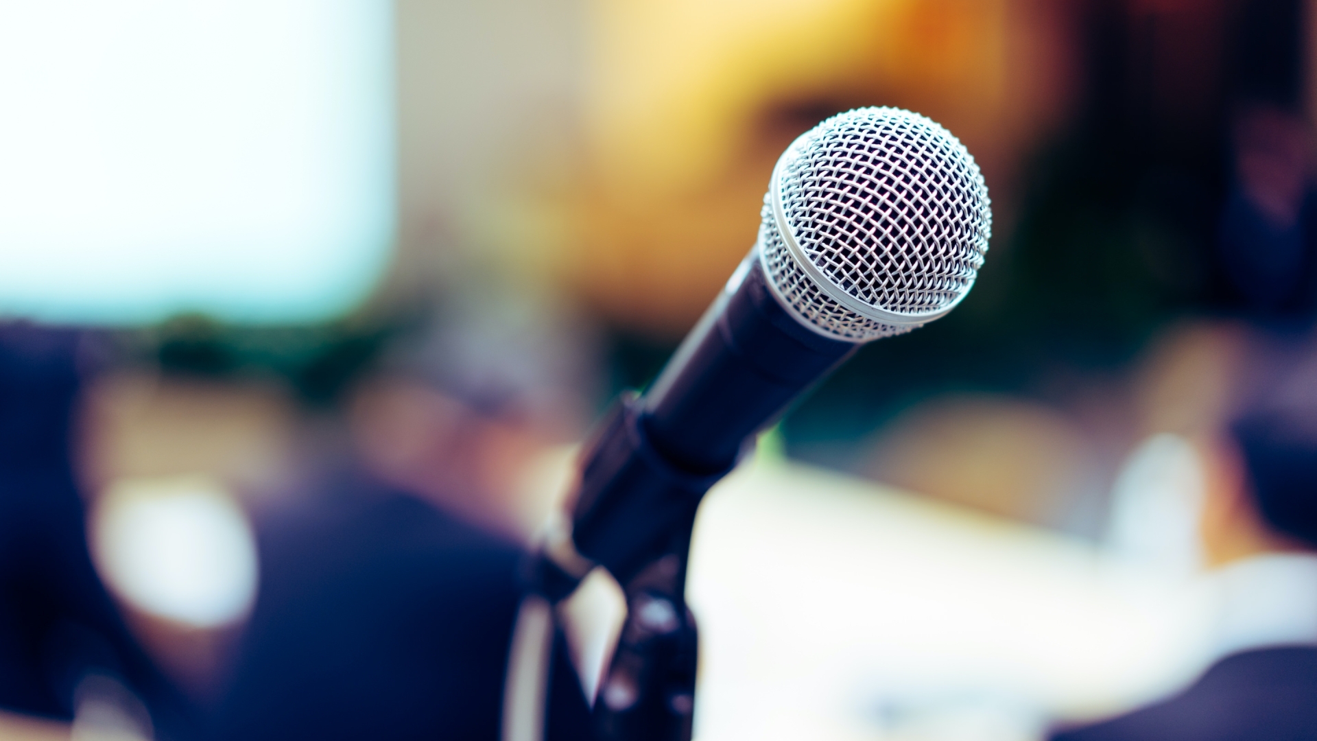 Microphone in foreground with blurred background.