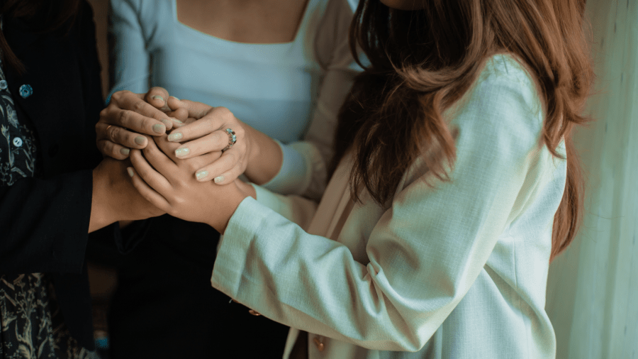 Three women holding hands.