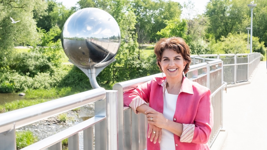 La commissaire à l'information et à la protection de la vie privée, Patricia Kosseim, pose pour une photo sur un pont, avec des arbres en arrière-plan.