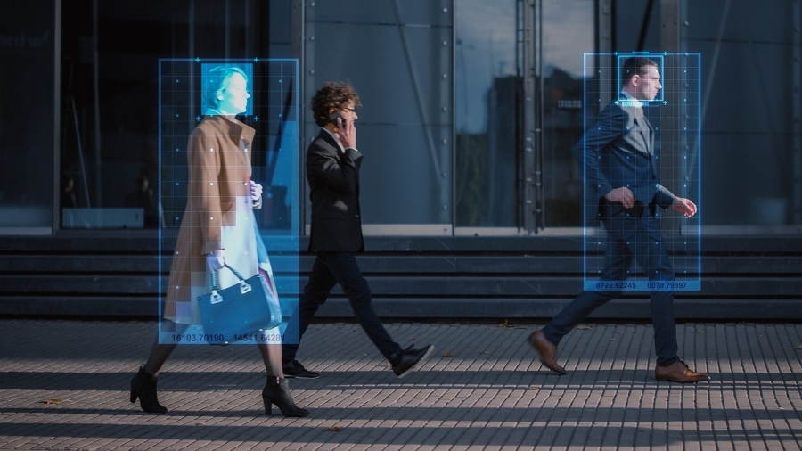 People walking down a city street as a surveillance camera tracks them.