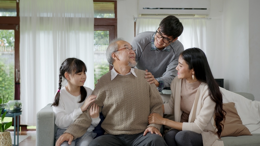 A multi-generational family sitting together on a couch.