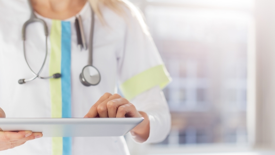 A doctor holding an iPad.