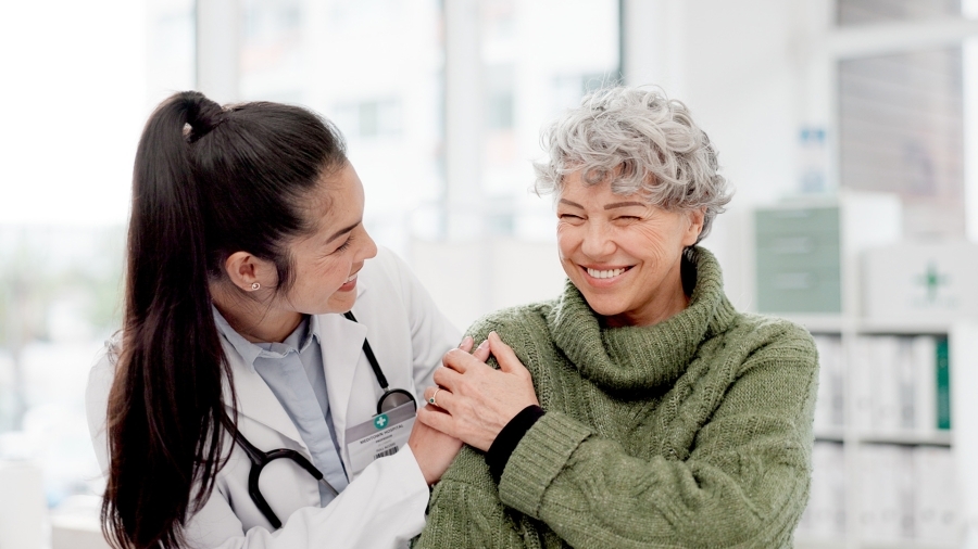 A doctor laughing with an older patient.