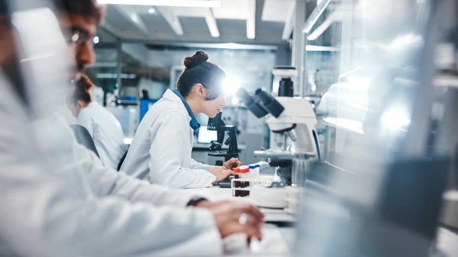 A medical researcher looking into a microscope.