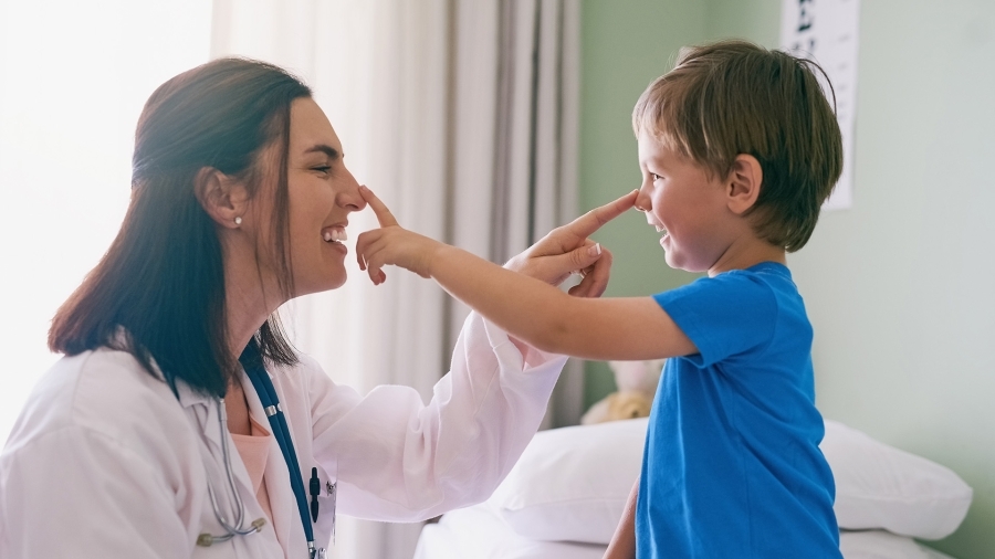 Médecin et jeune patient qui sourient et se touchent le nez.