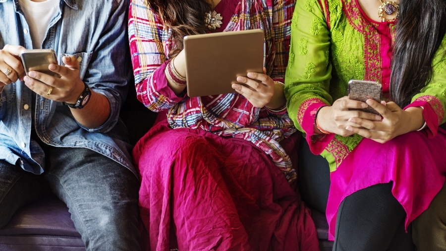 individuals sitting with mobile devices