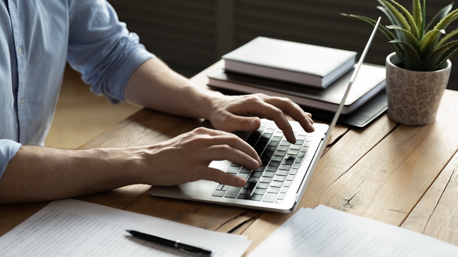 Hands typing on a laptop keyboard.