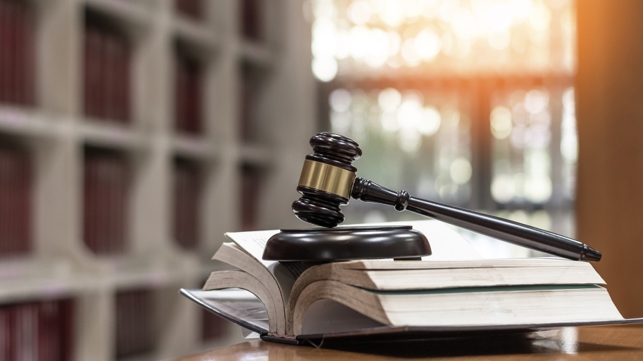 Un marteau posé sur un manuel de droit.
