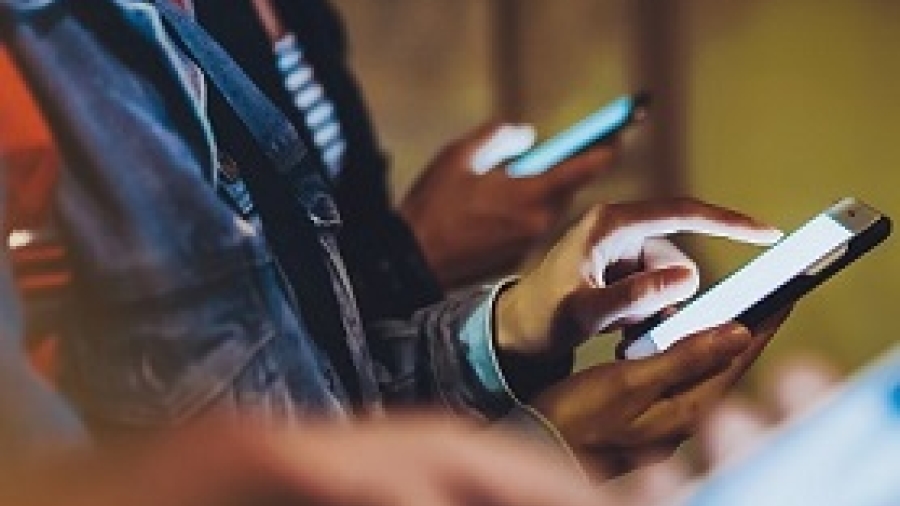People interacting with illuminated smartphones
