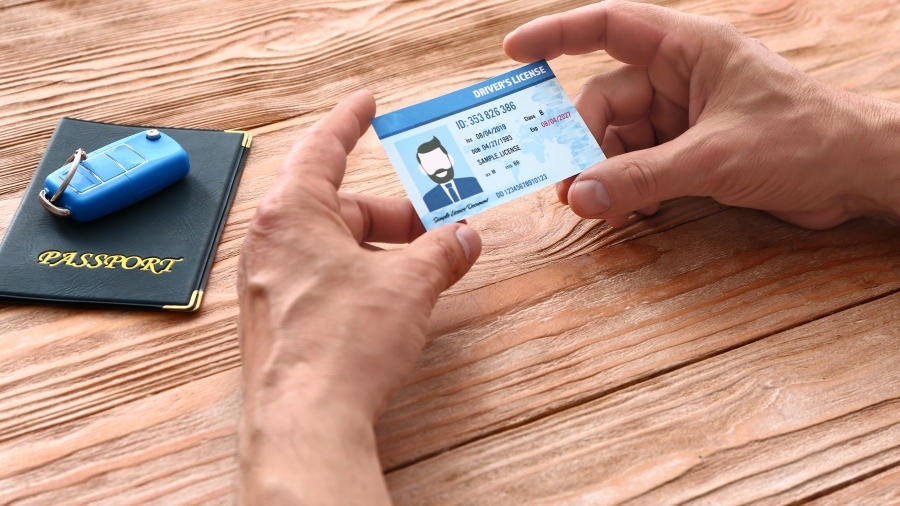 Hands holding a passport on a table, with a passport laying nearby.