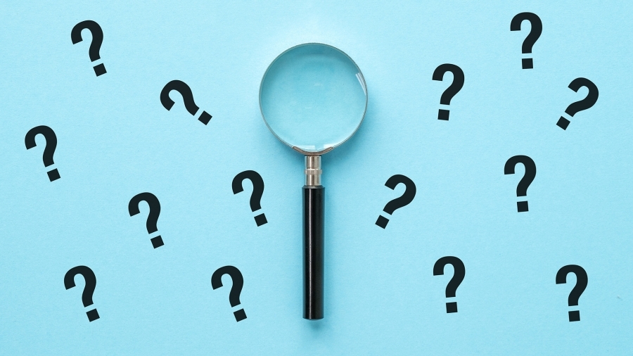 A magnifying glass surrounded by question marks, on a blue background.