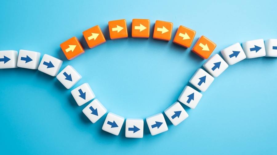 A long line of white dice with blue arrows, and a shorter line of orange dice with yellow arrows breaking off midway through.
