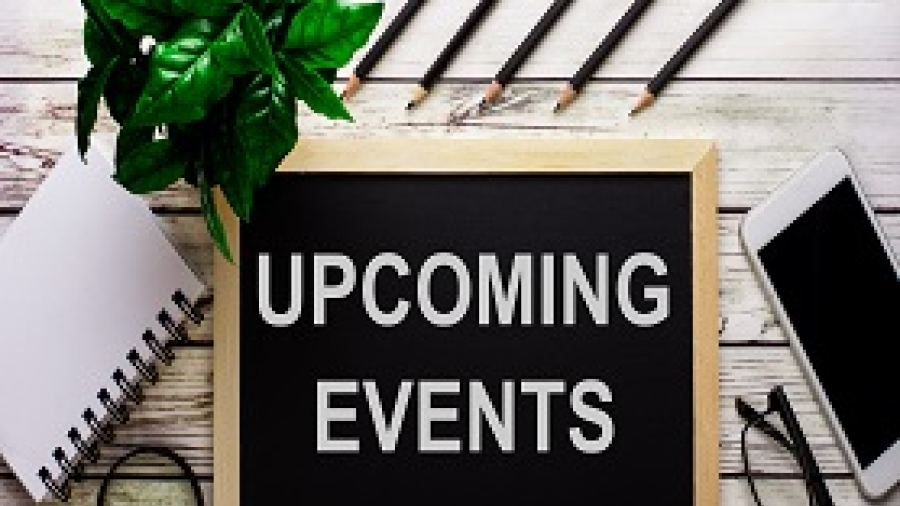 The words "upcoming events" on a small chalkboard laying on a table with a notepad and iPhone beside it