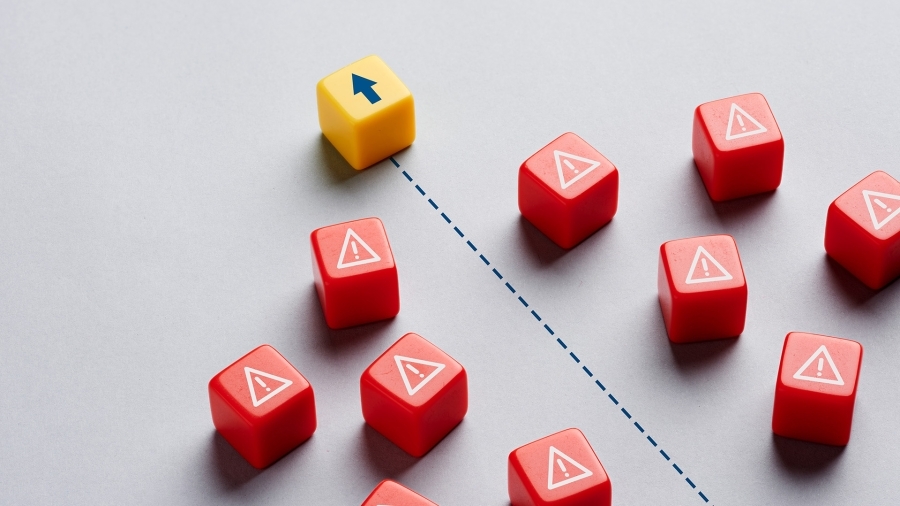 A yellow die with an arrow on it, surrounded by red dice with warning symbols.