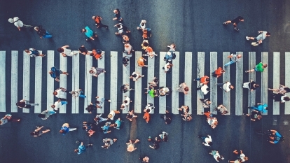 An aerial view of people walking in a crosswalk.