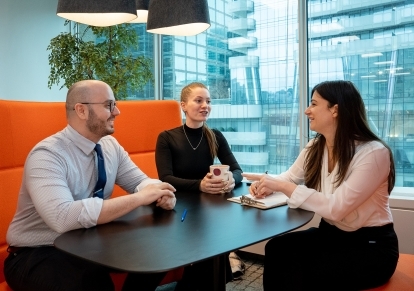 Three IPC staff members having a conversation over coffee.